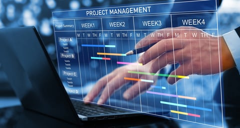Project manager working on laptop and updating tasks and milestones progress planning with Gantt chart scheduling interface